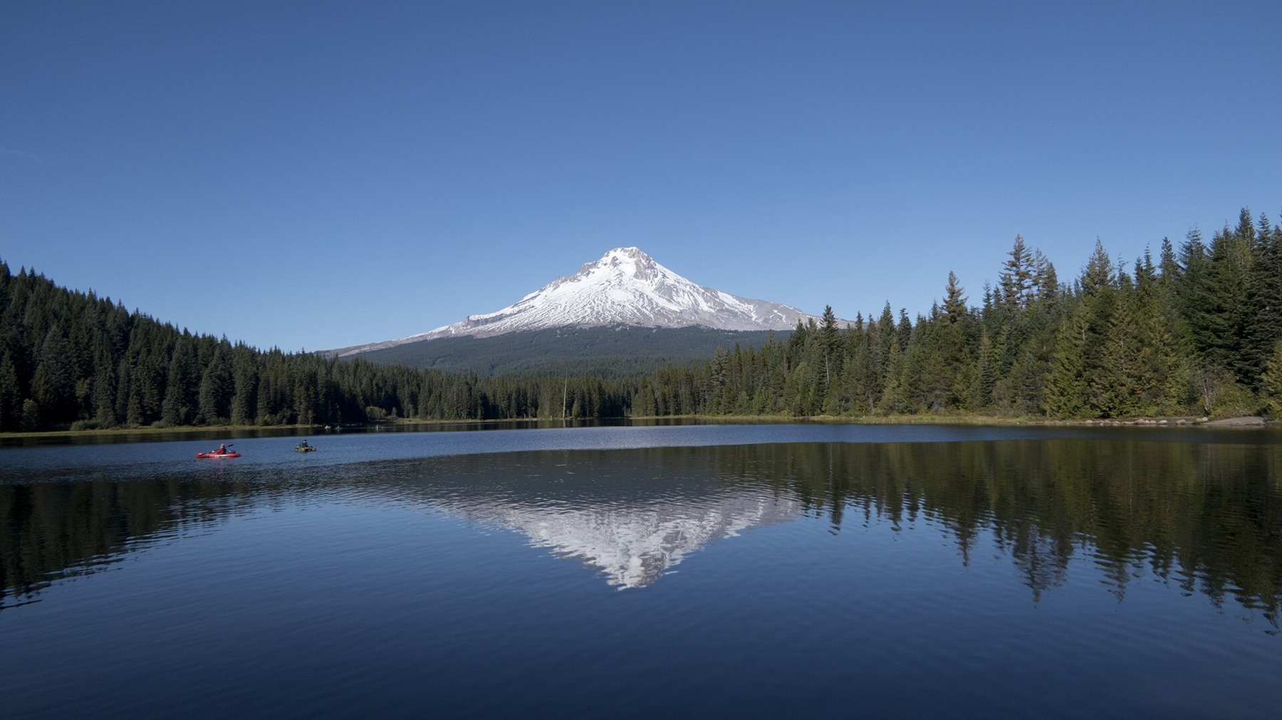 Paddlers on bright Trillium Lake below Mount Hood